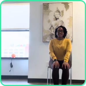 Video thumbnail for a 15 minute seated yoga class, woman sitting on a chair with hands resting on her knees in front of a painting.